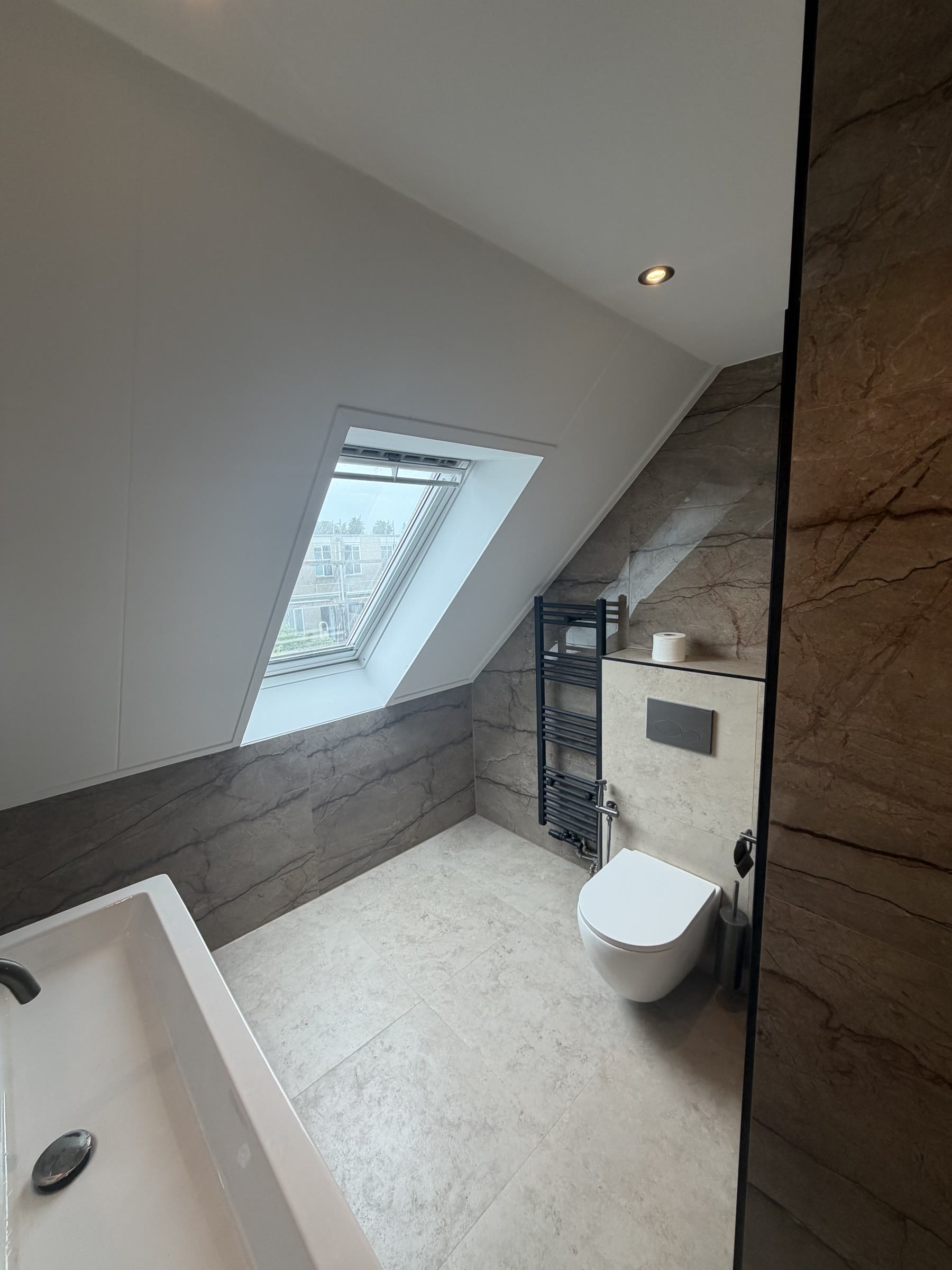 Overzicht van complete badkamer met ligbad, toilet en douche