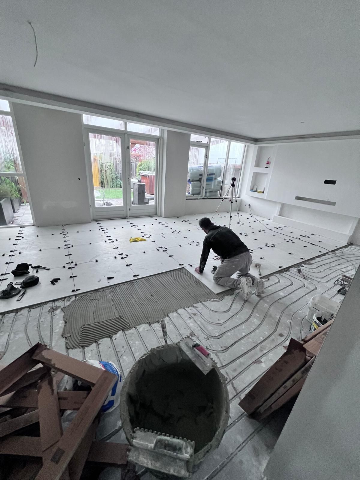 Grote tegelvloer in woonkamer tijdens plaatsing
